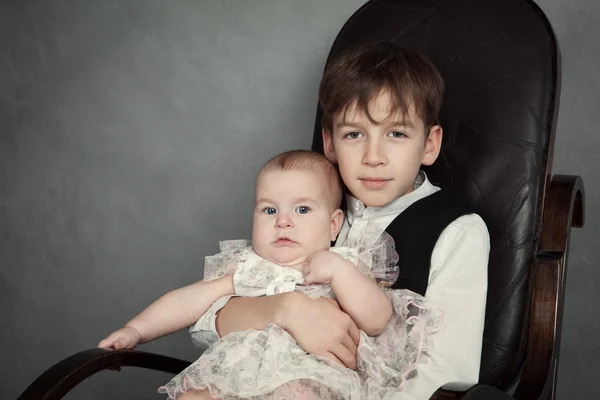 Retrato de irmão e irmã em fundo cinza — Fotografia de Stock