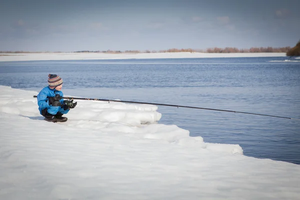 Boy fishing with rod on river in winter. — Stock Photo, Image