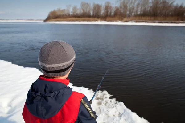 Boy fishing with rod on river in winter. — Stock Photo, Image
