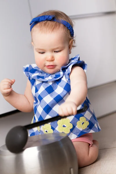 Маленькая милая девочка играет на кухне — стоковое фото
