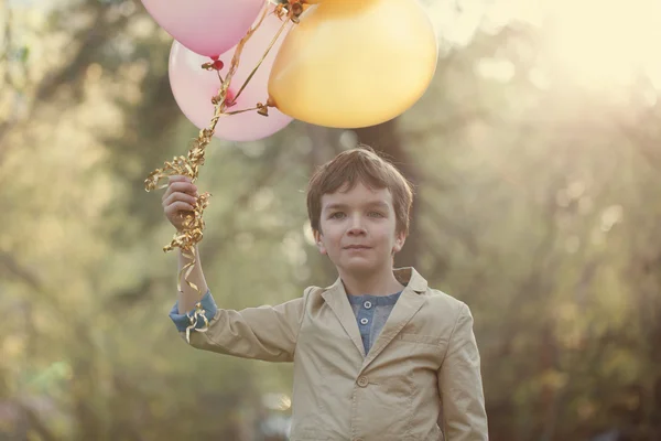 Criança feliz com balões coloridos em celebração — Fotografia de Stock
