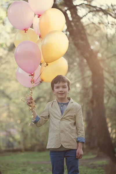 Niño feliz con globos de colores en celebración — Foto de Stock