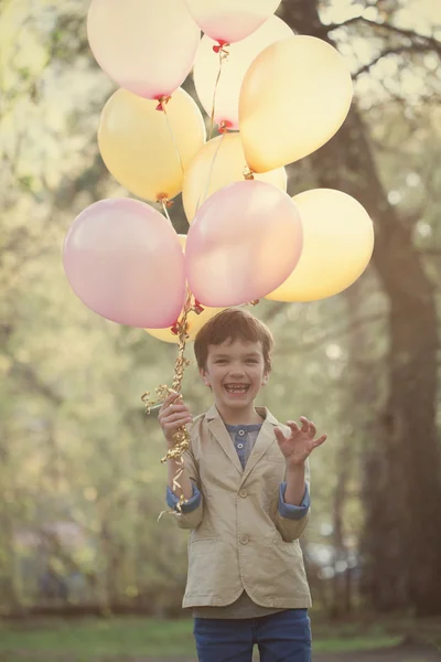 Gelukkig kind met kleurrijke ballonnen in de viering — Stockfoto