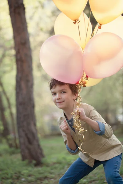 Lyckligt barn med färgglada ballonger för att fira — Stockfoto