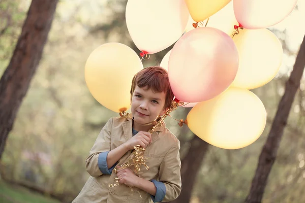Niño feliz con globos de colores en celebración — Foto de Stock