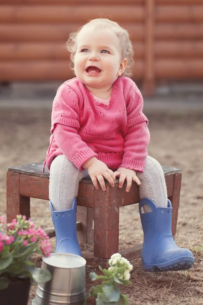 Linda niña en vestido rosa pone flores —  Fotos de Stock