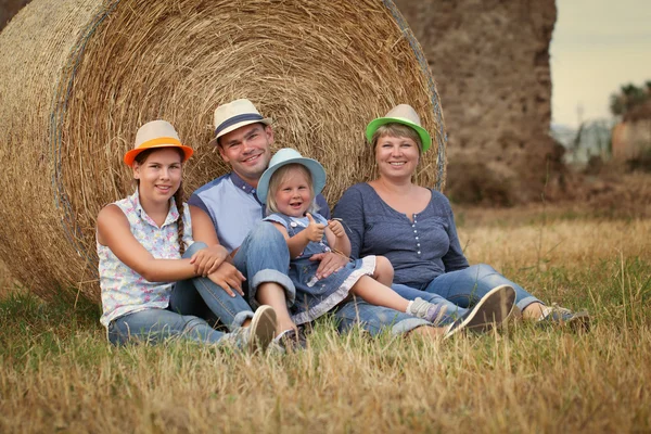 Glad familj kul på fältet med höstackar — Stockfoto