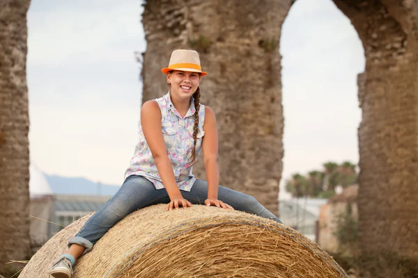 Porträtt av glad glad tonåring sitter på höstacken — Stockfoto