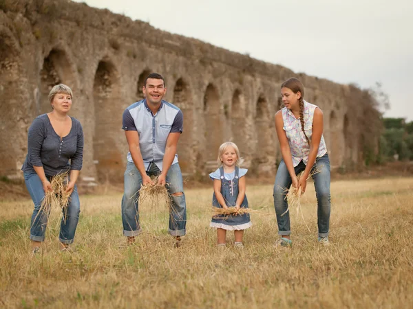 Glad familj kul på fältet med höstackar — Stockfoto