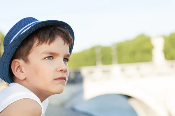 Portrait of serious pensive child on background of bridge — Stock Photo, Image