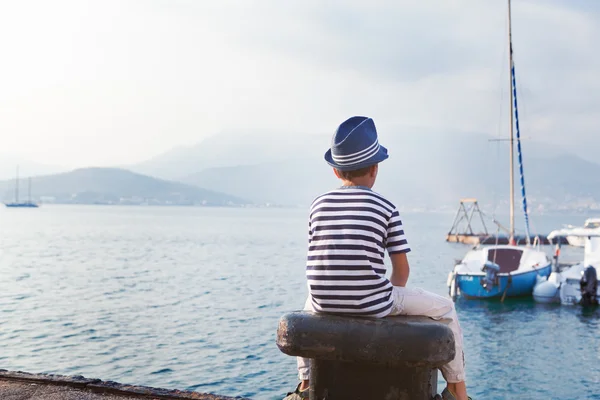 Kind in hoed op zoek op zee en schip — Stockfoto