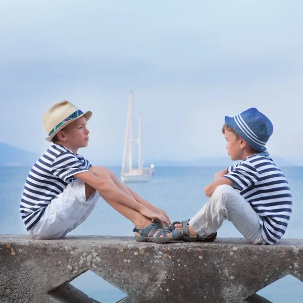 Dois irmãos semelhantes sentados à beira-mar , — Fotografia de Stock