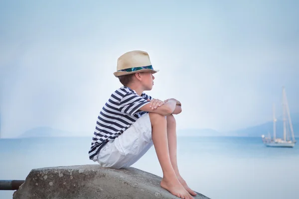 Nadenkende jongen kijkt bij schip op zee en dromen — Stockfoto