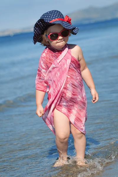 Mutlu kız şapka ve güneş gözlüğü, deniz kenarında yürüyüş — Stok fotoğraf