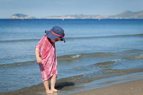 Mutlu kız şapka ve güneş gözlüğü, deniz kenarında yürüyüş — Stok fotoğraf