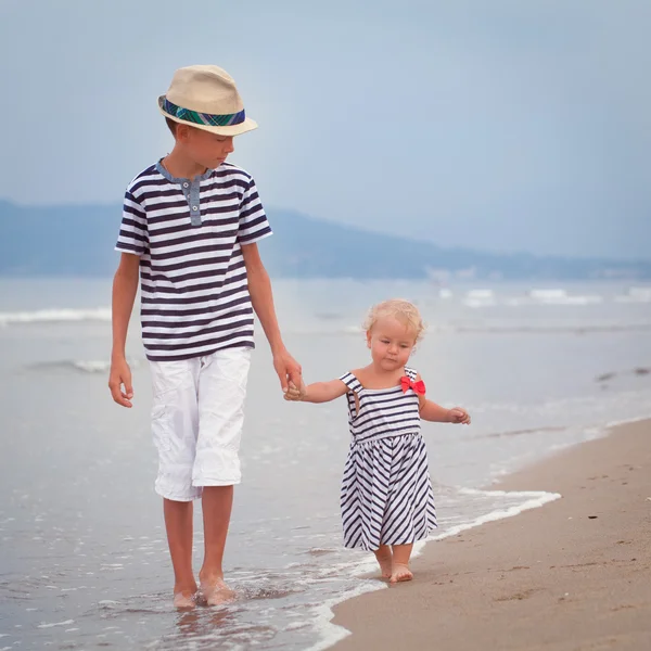 Szczęśliwy starszego brata i młodszą siostrę ładny, spacery nad morzem — Zdjęcie stockowe