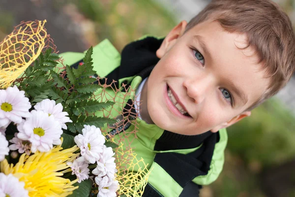 Retrato de menino alegre feliz com flores — Fotografia de Stock