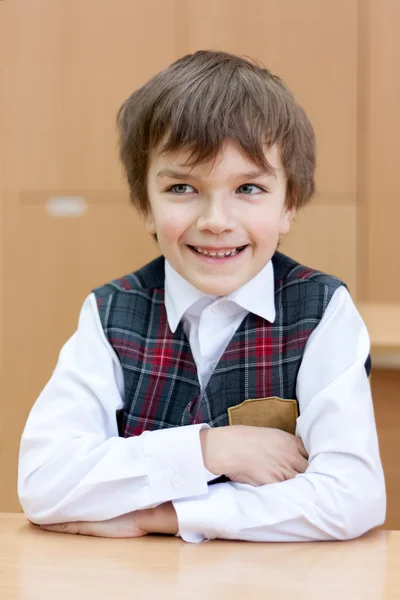 Fleißiger Schüler sitzt am Schreibtisch, Klassenzimmer — Stockfoto