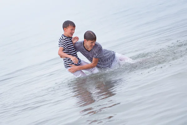 Dois alegres, felizes, irmão joga no mar — Fotografia de Stock