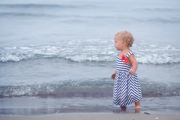 Kleine mooie babymeisje wandelen langs de kust — Stockfoto