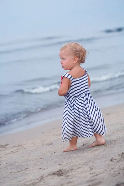 Pequeña niña bonita caminando a lo largo de la costa — Foto de Stock