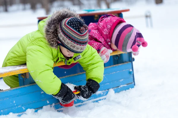 Happy brother and sister play with snow in park — Stock Photo, Image