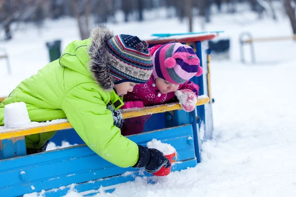 Happy brother and sister play with snow in park — Stock Photo, Image