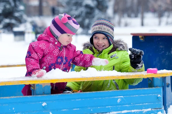Счастливые брат и сестра играют со снегом в парке — стоковое фото