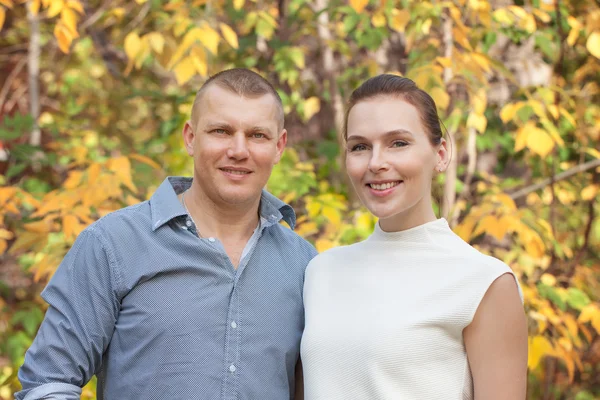 Šťastný manžel srostlými manželka v podzimním parku — Stock fotografie