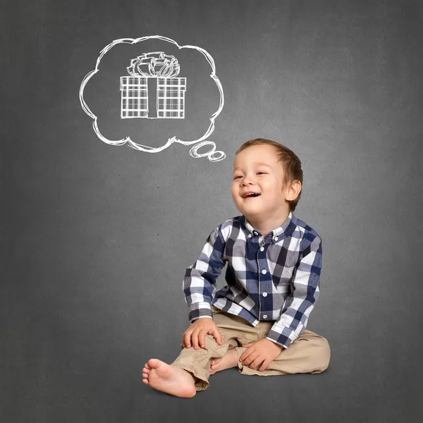 Cute boy dreaming about gift — Stock Photo, Image