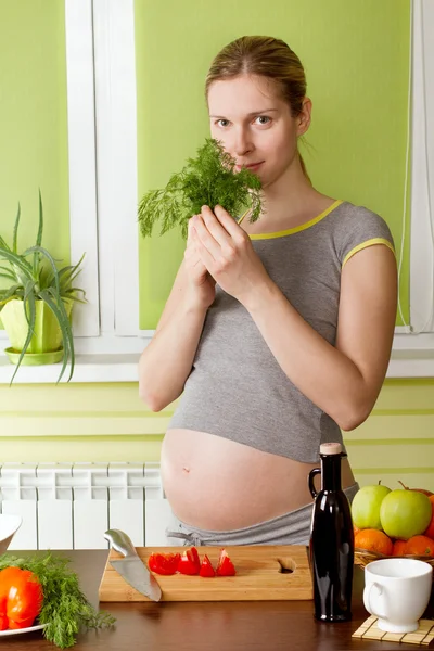Mujer embarazada cocinando alimentos saludables Imagen de stock