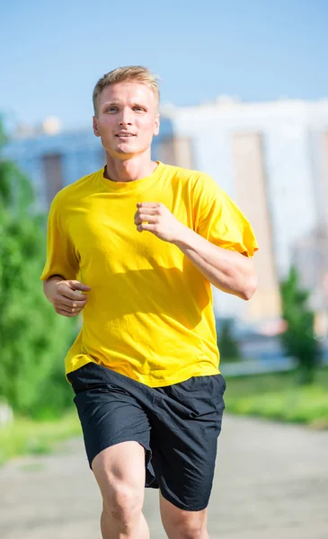 Sportovní muž, běhání v městském parku ulici. Venkovní fitness. — Stock fotografie