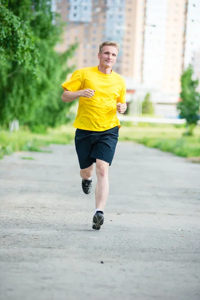 Sportieve man joggen in straat skyline van de stad. Buiten fitness. — Stockfoto