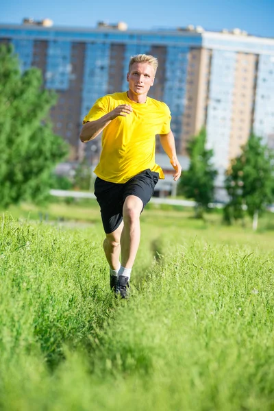 Sporty man jogging in city street park. Outdoor fitness. — Stock Photo, Image