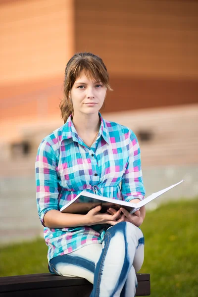 Diák lány copybook a padon. Nyári campus park. — Stock Fotó