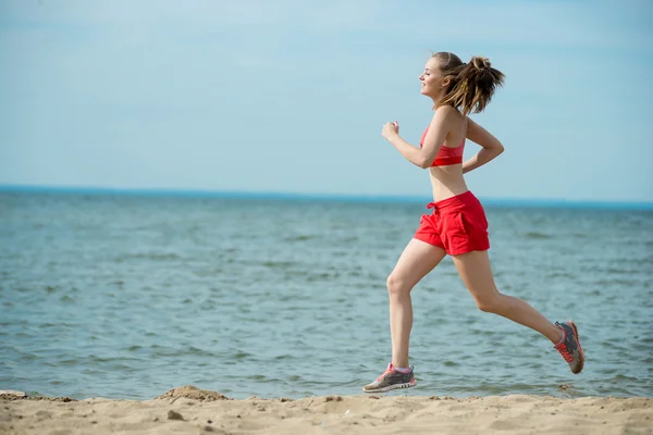 Giovane signora che corre alla soleggiata spiaggia di sabbia estiva. Allenati. Jogging — Foto Stock