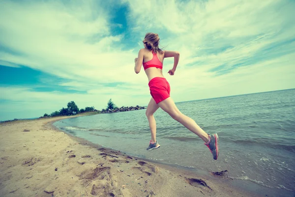 Ung dam kör på solig sommar sand stranden. Träning. JOG — Stockfoto