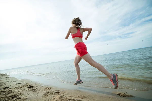Güneşli yaz kum plajda çalışan genç bayan. Egzersiz. Jog