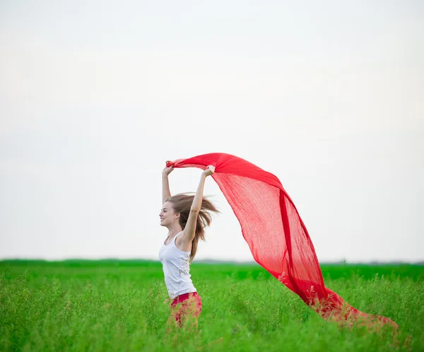 Young lady runing with tissue in green field. Woman with scarf. — Stock Photo, Image