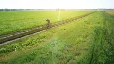 Anteni: yeşil ve sarı alan ile kırsal Road bisiklet üzerinde Bisiklete binme genç adam.
