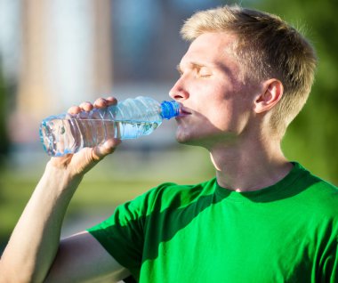 Yorgun bir adam içme suyu fitness sonra plastik bir şişe