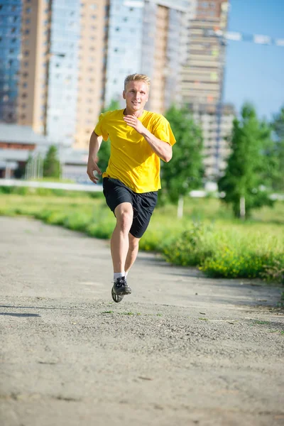 スポーティな男は都市通り公園でジョギングします。屋外フィットネス. — ストック写真