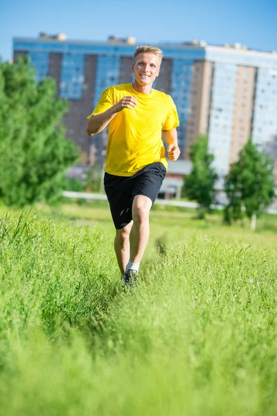 Sportieve man joggen in straat skyline van de stad. Buiten fitness. — Stockfoto