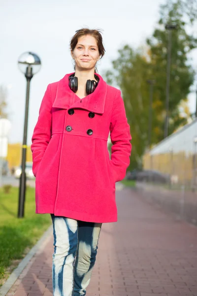 Sonbahar street yürüyüş kırmızı paltolu güzel kadın. — Stok fotoğraf