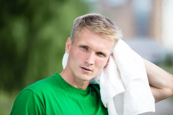 Trött man efter fitness tid och träning. Med vit handduk — Stockfoto