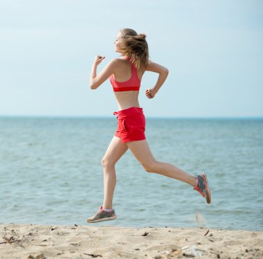 Güneşli yaz kum plajda çalışan genç bayan. Egzersiz. Jog