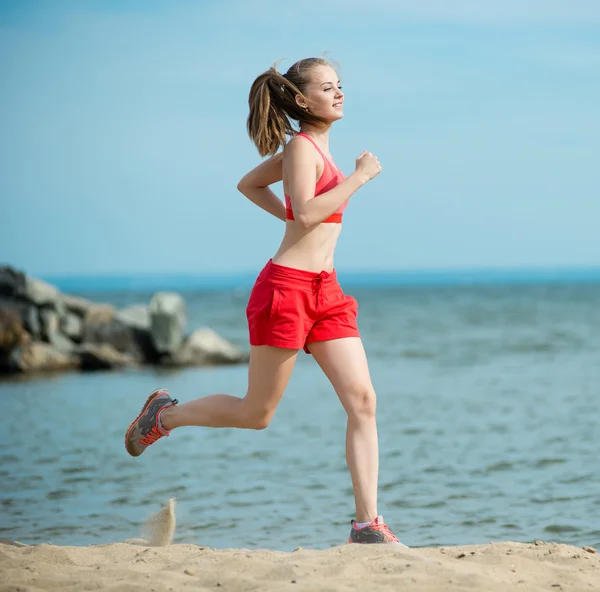 Young lady running at the sunny summer sand beach. Workout.  Jog — Stock Photo, Image