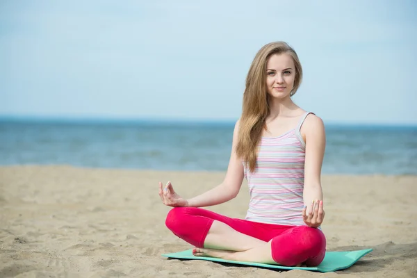 Młoda dama Praktykuje jogę. Trening w pobliżu wybrzeża Oceanu. — Zdjęcie stockowe