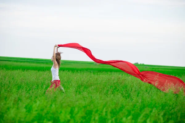 Молода леді біжить з тканиною в зеленому полі. Жінка з шарфом . — стокове фото