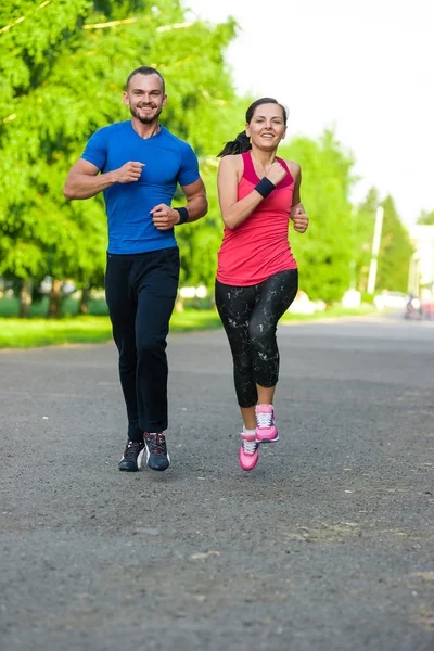 Runners training outdoors working out. City running couple jogging outside.